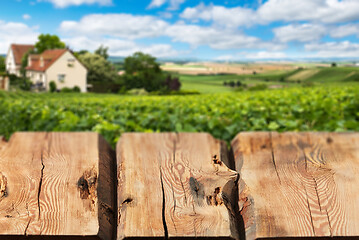 Image showing Wooden boards or countertop against blurred countryside landscape on background. Use as mockup for display or montage of your products. Close up