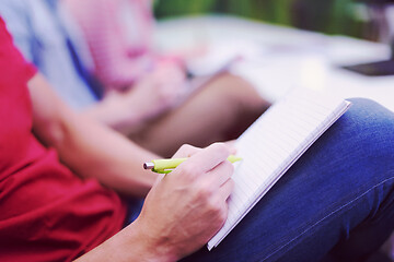 Image showing male student taking notes in classroom