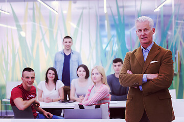 Image showing portrait of  teacher with students group in background