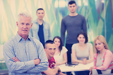 Image showing portrait of  teacher with students group in background