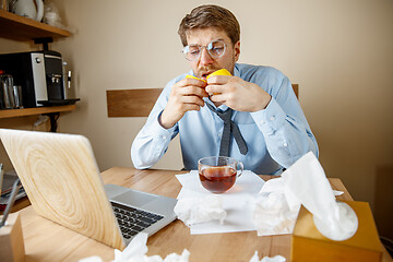 Image showing Sick man while working in office, businessman caught cold, seasonal flu.