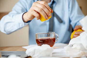 Image showing Sick man while working in office, businessman caught cold, seasonal flu.