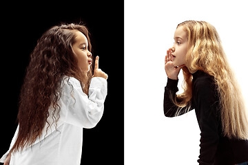 Image showing The young teen girls whispering a secret behind her hand over pink background