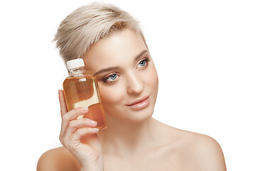 Image showing Beauty concept. The pretty woman with perfect skin holding oil bottle