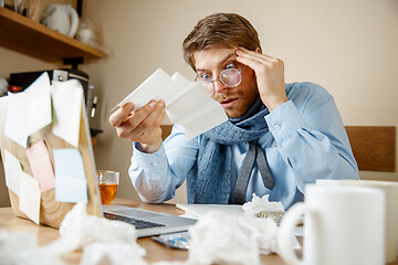 Image showing Sick man while working in office, businessman caught cold, seasonal flu.