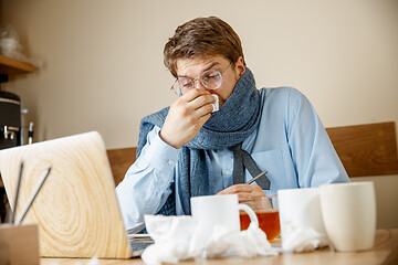 Image showing Sick man while working in office, businessman caught cold, seasonal flu.