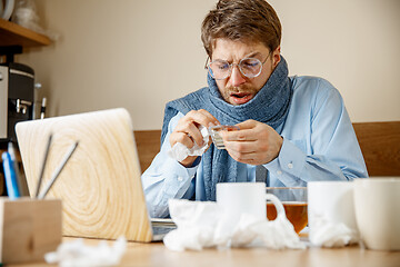 Image showing Sick man while working in office, businessman caught cold, seasonal flu.