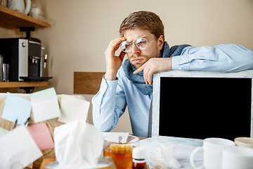 Image showing Sick man while working in office, businessman caught cold, seasonal flu.