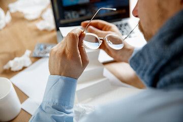 Image showing Sick man while working in office, businessman caught cold, seasonal flu.