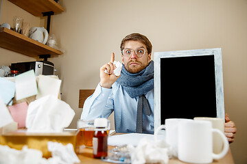 Image showing Sick man while working in office, businessman caught cold, seasonal flu.