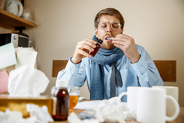 Image showing Sick man while working in office, businessman caught cold, seasonal flu.