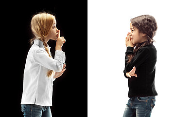 Image showing The young teen girls whispering a secret behind her hand over pink background