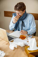 Image showing Sick man while working in office, businessman caught cold, seasonal flu.