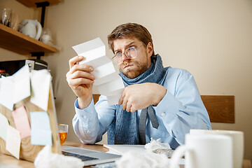 Image showing Sick man while working in office, businessman caught cold, seasonal flu.