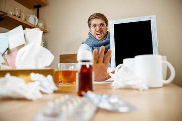 Image showing Sick man while working in office, businessman caught cold, seasonal flu.