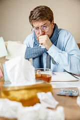 Image showing Sick man while working in office, businessman caught cold, seasonal flu.