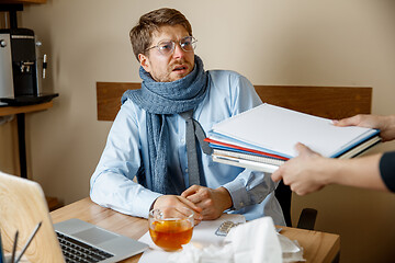 Image showing Sick man while working in office, businessman caught cold, seasonal flu.