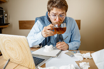 Image showing Sick man while working in office, businessman caught cold, seasonal flu.