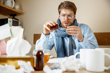 Image showing Sick man while working in office, businessman caught cold, seasonal flu.