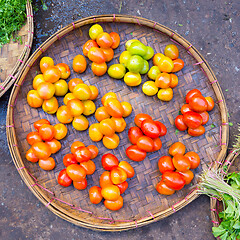 Image showing Fresh red tomatoes in basket beeing sold on local asian farmers market.