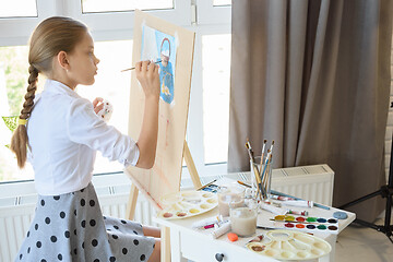 Image showing Girl gently draws still life sitting in front of a large light w