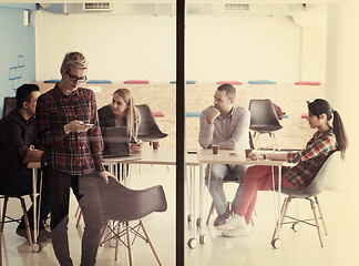 Image showing business woman at office speaking by phone  team on meeting in b