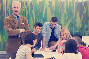 Image showing portrait of  teacher with students group in background