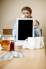 Image showing Sick man while working in office, businessman caught cold, seasonal flu.