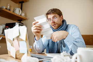 Image showing Sick man while working in office, businessman caught cold, seasonal flu.