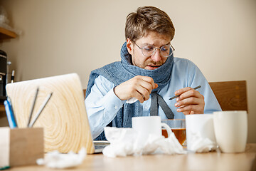 Image showing Sick man while working in office, businessman caught cold, seasonal flu.