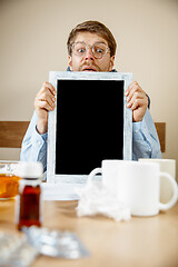 Image showing Sick man while working in office, businessman caught cold, seasonal flu.