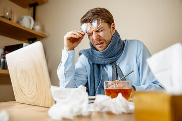 Image showing Sick man while working in office, businessman caught cold, seasonal flu.