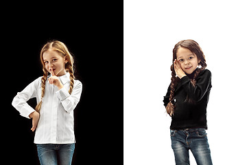 Image showing The young teen girls whispering a secret behind her hand over pink background