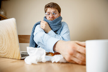 Image showing Sick man while working in office, businessman caught cold, seasonal flu.