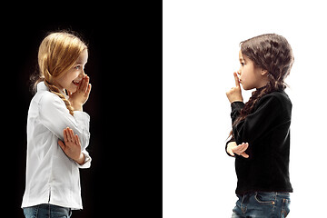 Image showing The young teen girls whispering a secret behind her hand over pink background