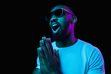 Image showing The neon portrait of a young smiling african man