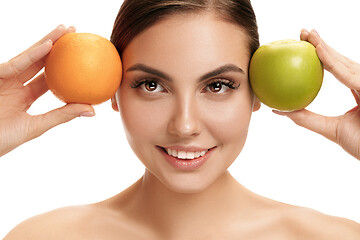 Image showing portrait of attractive caucasian smiling woman isolated on white studio shot eating green apple