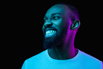 Image showing The neon portrait of a young smiling african man