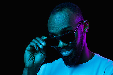 Image showing The neon portrait of a young smiling african man