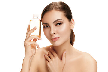 Image showing Beauty concept. The pretty woman with perfect skin holding oil bottle