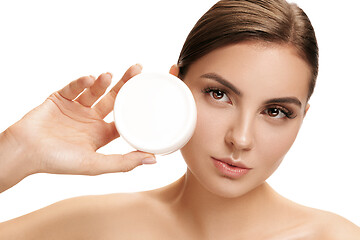 Image showing Cute girl preparing to start her day. She is applying moisturizer cream on face.