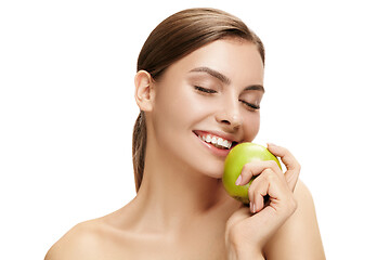 Image showing portrait of attractive caucasian smiling woman isolated on white studio shot eating green apple