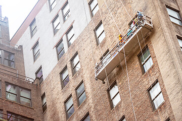 Image showing workers hanging on a house facade in New York