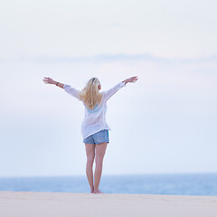 Image showing Free woman enjoying freedom on beach in morning.