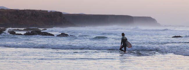 Image showing Surfers on beach with surfboard.