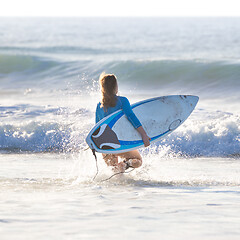 Image showing Silhouette of surfer on beach with surfboard.