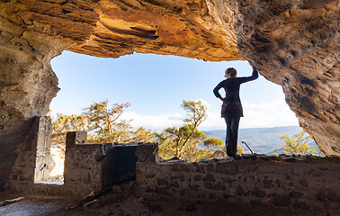 Image showing Woman looking out to mountain views from a cave