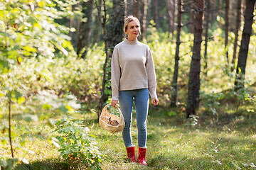 Image showing woman with basket picking mushrooms in forest