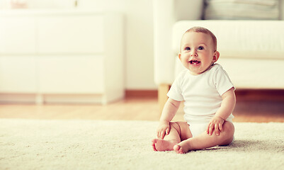 Image showing happy baby boy or girl sitting on floor at home