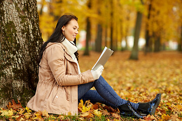 Image showing woman reading book at autumn park